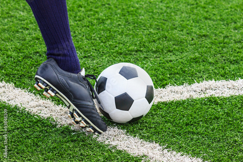 Photo: foot kicking soccer ball on corner foot kicking soccer ball on corner