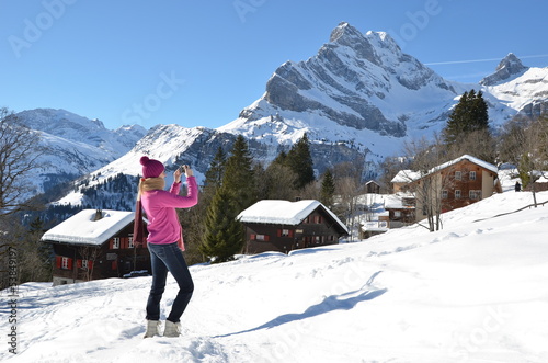 Photo: Girl taking a photo in the Swiss Alps Girl taking a photo in the Swiss Alps