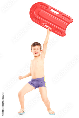 Photo: Full length portrait of a boy holding a swimming float and gestu Full length portrait of a boy holding a swimming float and gestu