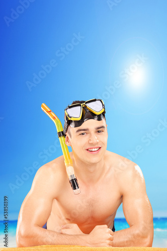 Photo: Young man wearing a snorkeling mask on a beach Young man wearing a snorkeling mask on a beach