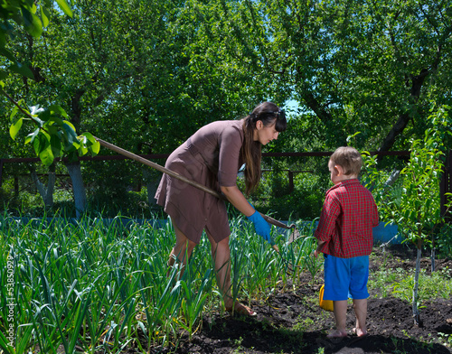Photo: Little boy helping his mother in the garden Little boy helping his mother in the garden