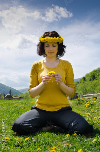 Photo: Young woman sitting in a meadow Young woman sitting in a meadow
