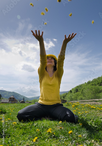 Photo: Young woman throws yellow flowers in the air Young woman throws yellow flowers in the air