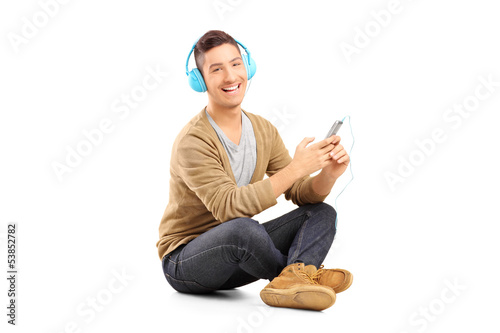Photo: Guy sitting on a floor and listening music on headphones from hi Guy sitting on a floor and listening music on headphones from hi