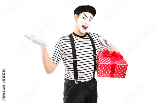 Photo: Male mime artist holding a gift box and gesturing with his hand Male mime artist holding a gift box and gesturing with his hand