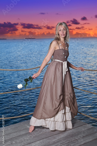 Photo: The beautiful woman on a wooden scaffold over the sea The beautiful woman on a wooden scaffold over the sea