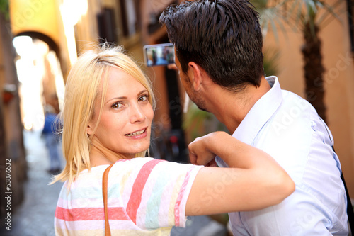 Photo: Couple of tourists taking picture in the streets of Rome Couple of tourists taking picture in the streets of Rome