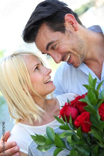 Photo: Man giving red roses to woman Man giving red roses to woman