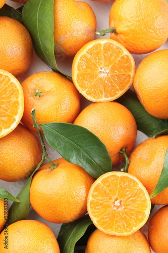 Photo: Top view of fresh tangerines with leaves. Top view of fresh tangerines with leaves.