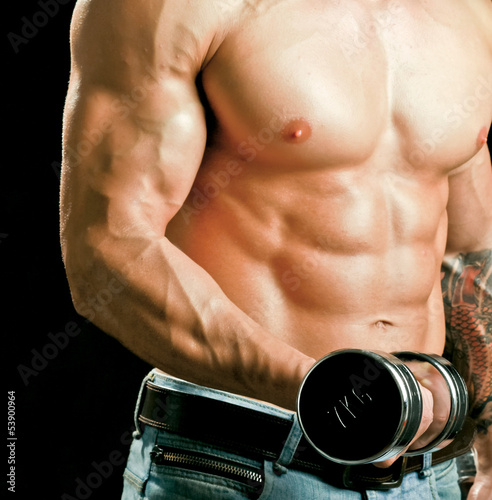 Photo: Handsome muscular man working out with dumbbells Handsome muscular man working out with dumbbells