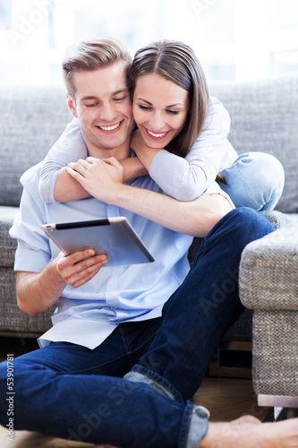 Photo: Young couple looking at digital tablet Young couple looking at digital tablet