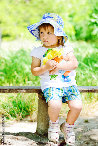 Photo: girl with doll on the bench girl with doll on the bench