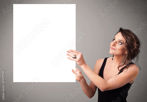 Photo: Young woman presenting white paper copy space Young woman presenting white paper copy space