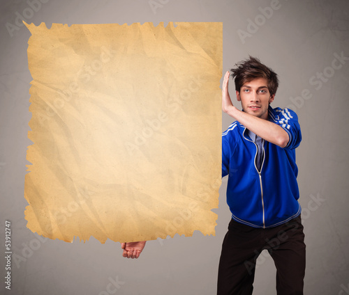 Photo: Young man presenting old paper copy space Young man presenting old paper copy space