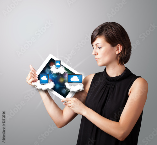 Photo: young woman holding tablet with modern devices in clouds young woman holding tablet with modern devices in clouds