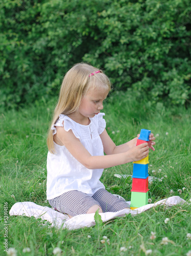 Photo: Little girl playing blocks in the park Little girl playing blocks in the park