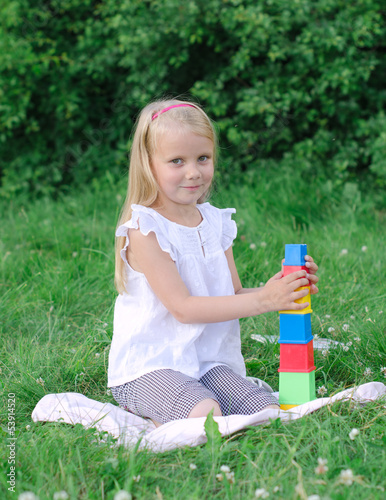 Photo: Little girl playing blocks in the park Little girl playing blocks in the park
