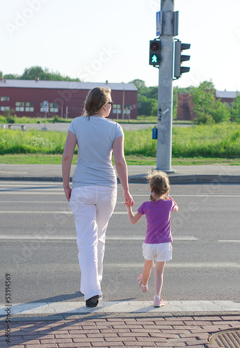 Photo: Mother and child crossing the road. Back view. Mother and child crossing the road. Back view.