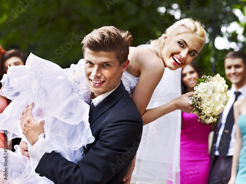 Photo: Groom carries his bride over shoulder. Groom carries his bride over shoulder.