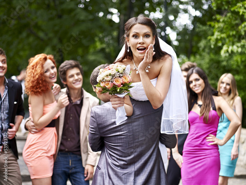 Photo: Groom carries his bride over shoulder. Groom carries his bride over shoulder.