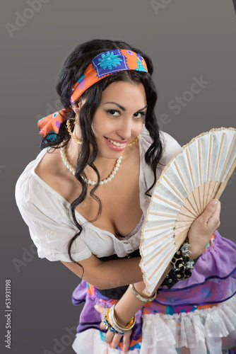 Photo: Portrait of smiling Gypsy girl with fan, gray background Portrait of smiling Gypsy girl with fan, gray background