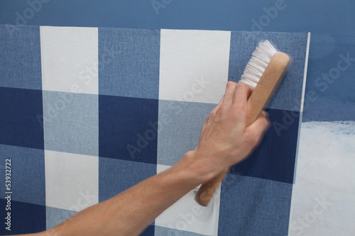 Photo: decorator hanging wallpaper with work tool in motion decorator hanging wallpaper with work tool in motion