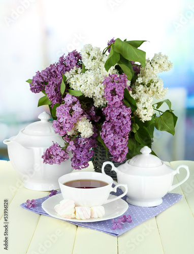 Photo: Composition with beautiful lilac flowers, tea service Composition with beautiful lilac flowers, tea service