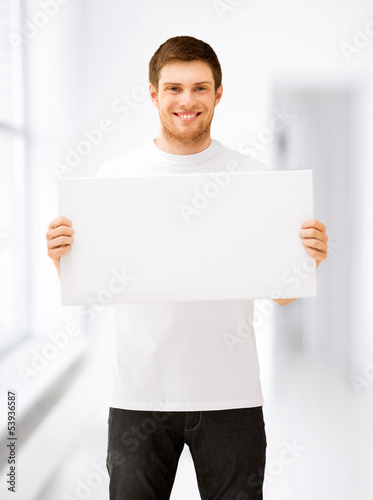 Photo: young man holding white blank board young man holding white blank board