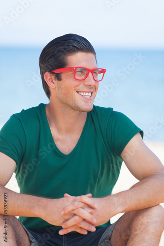 Photo: Handsome young man at beach background Handsome young man at beach background