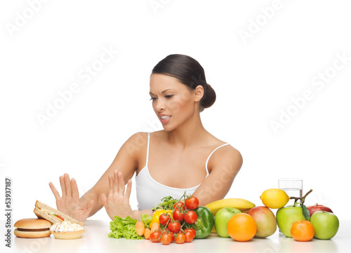Photo: woman with fruits rejecting hamburger woman with fruits rejecting hamburger