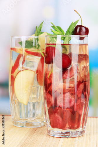 Photo: Glasses of fruit drinks with ice cubes on table in cafe Glasses of fruit drinks with ice cubes on table in cafe