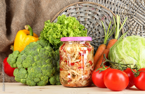 Photo: Fresh vegetables and canned on table close up Fresh vegetables and canned on table close up