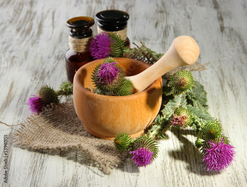 Photo: Medicine bottles and mortar with thistle flowers Medicine bottles and mortar with thistle flowers