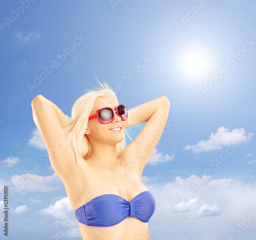 Photo: Blond woman in bikini relaxing against a blue sky Blond woman in bikini relaxing against a blue sky
