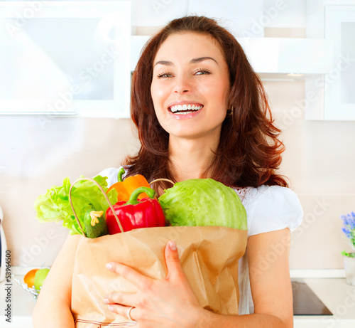 Photo: Happy Young Woman with vegetables in shopping bag. Diet Concept Happy Young Woman with vegetables in shopping bag. Diet Concept