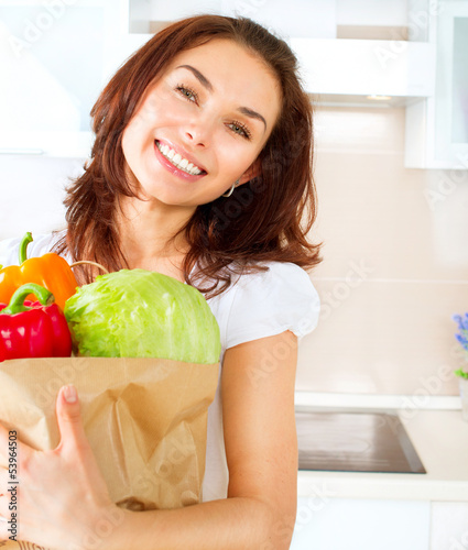 Photo: Happy Young Woman with vegetables in shopping bag. Diet Concept Happy Young Woman with vegetables in shopping bag. Diet Concept