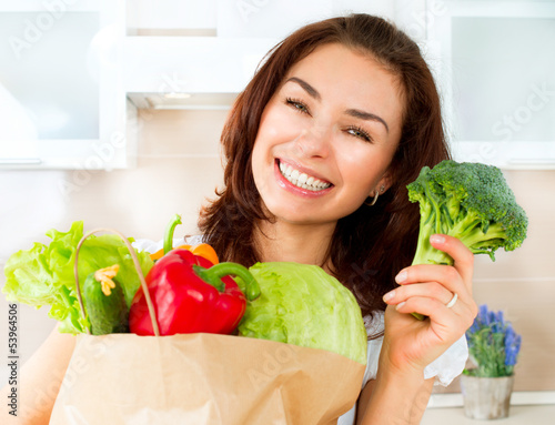 Photo: Happy Young Woman with vegetables in shopping bag. Diet Concept Happy Young Woman with vegetables in shopping bag. Diet Concept