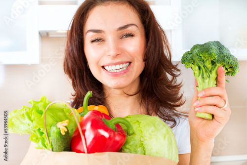 Photo: Happy Young Woman with vegetables in shopping bag. Diet Concept Happy Young Woman with vegetables in shopping bag. Diet Concept