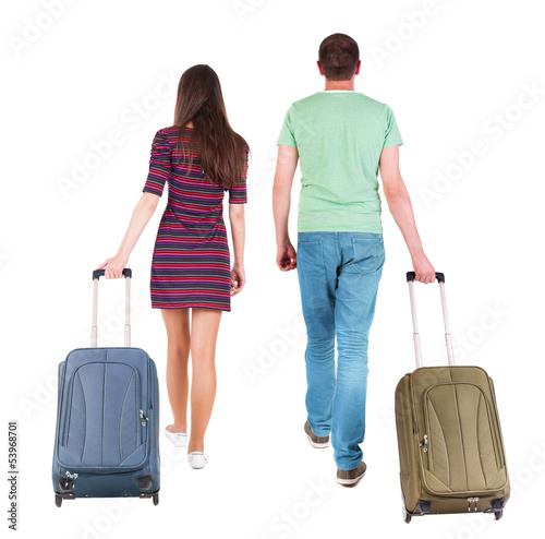 Photo: back view of walking couple with suitcase. back view of walking couple with suitcase.