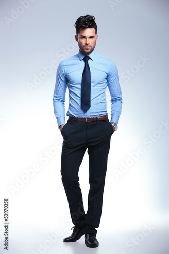 Photo: jacketless business man stands with hands in pockets jacketless business man stands with hands in pockets