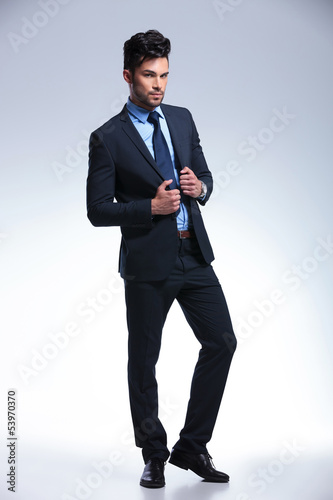 Photo: business man stands with hands on jacket business man stands with hands on jacket