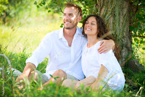 Photo: Young Couple Having Picnic in a Park. Happy Family Outdoor Young Couple Having Picnic in a Park. Happy Family Outdoor