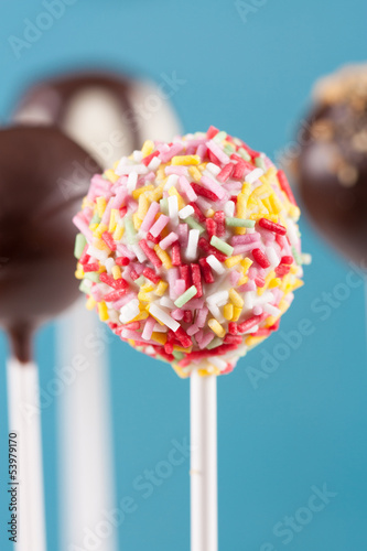 Photo: Colorful topping cake pop on blue background Colorful topping cake pop on blue background