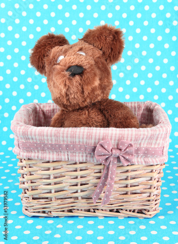 Photo: Beautiful basket with toy bear on a blue background Beautiful basket with toy bear on a blue background