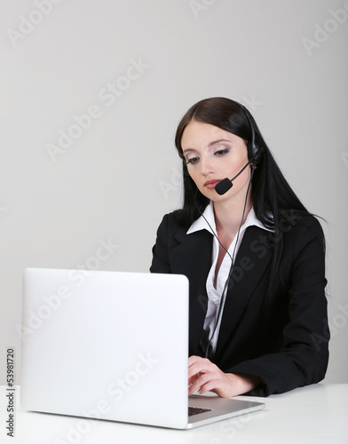 Photo: Call center operator at work, on gray background Call center operator at work, on gray background