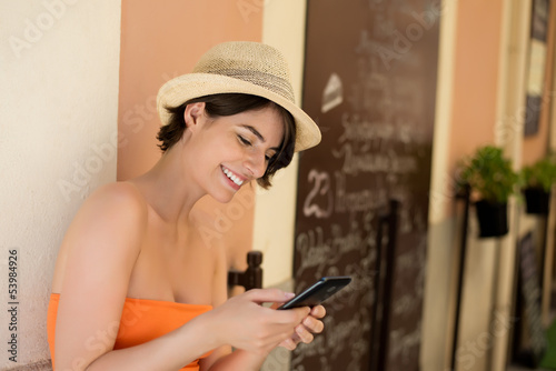 Photo: schöne frau schreibt sms aus einer stadt im süden schöne frau schreibt sms aus einer stadt im süden