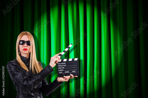 Photo: Girl with movie board against curtains Girl with movie board against curtains
