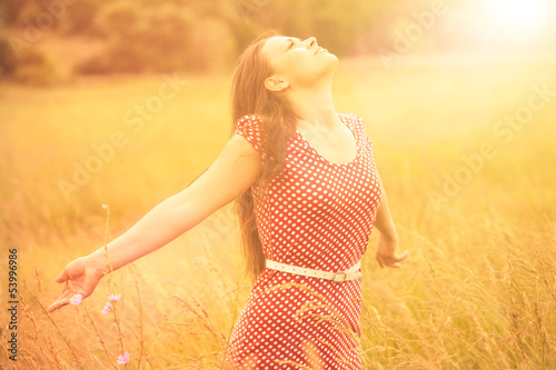 Photo: Summer Fun. Young happy woman enjoying sunlight on the wheat mea Summer Fun. Young happy woman enjoying sunlight on the wheat mea