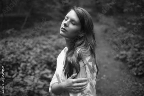 Photo: Unhappy girl standing in the middle of a forest Unhappy girl standing in the middle of a forest