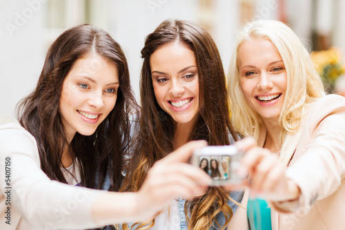 Photo: beautiful girls taking picture in cafe in city beautiful girls taking picture in cafe in city